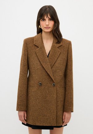 Bruine textuur blazer met een dubbelgebreide voorkant, scherpe revers en twee knopen. Bevat lange mouwen en zijzakken.