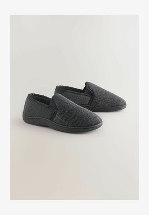 Szürke textúrált felsőrésszel rendelkező vászon slip-on cipők, lekerekített orral és fekete gumitalppal, melyek könnyű felvételt biztosító elasztikus oldalsó panelekkel rendelkeznek.