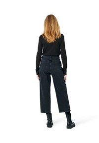 Höga, vida jeans i mörkt denim. Funktioner inkluderar en knappstängning, två bakfickor och en fransad nederkant.