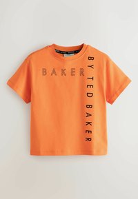 Oranžikas lühikeste varrukatega puuvillane t-särk. Ees on musta tekstiga kiri "BAKER" vertikaalselt ja "BY TED BAKER" horisontaalselt.