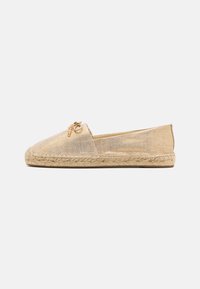 Espadrille instap-schoen van beige stof met een geweven jute zool. Kenmerkt zich door een kleine gouden kettingaccent op de bovenkant.