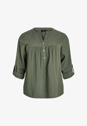 Zielona bawełniana bluzka z rękawami do połowy przedramienia, zapinana na guziki z przodu, z teksturowanym karczkiem. Charakteryzuje się luźnym krojem i plisowanym wzorem.