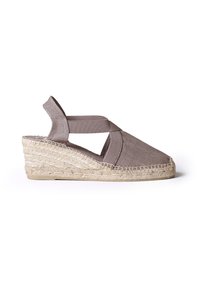 Beige wedge espadrille dengan desain tali silang dan aksen elastis. Sol jute anyaman, bagian atas kanvas tekstur, belakang terbuka.