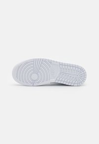 Vit sneaker sula med cirkulära och mönstrade spår. Slät yta, med Nike-logotypen inom en rektangulär panel. Minimalistisk design.