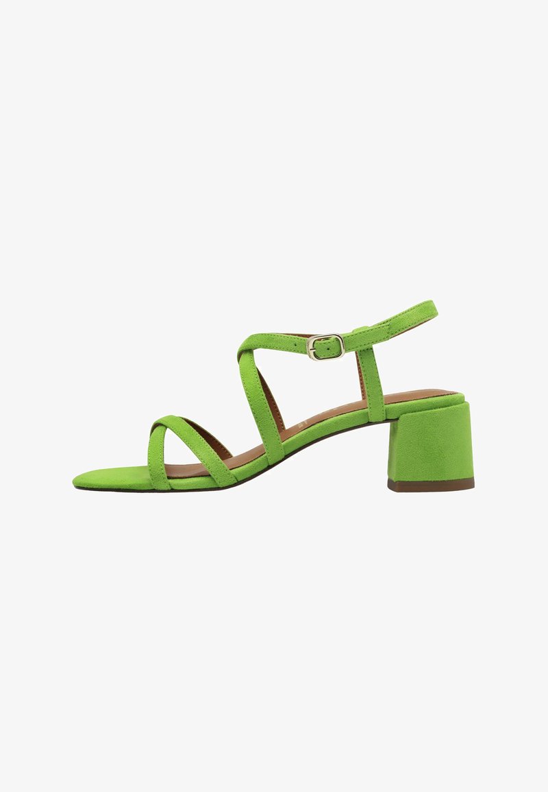 Green suede heeled sandal with a block heel, featuring adjustable ankle strap, crisscross design, and a smooth, textured finish.