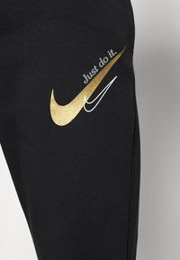 Black fabric featuring two Nike swoosh logos, one gold and one white, with text "Just do it." above the gold swoosh.
