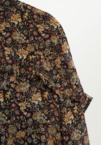 Tissu noir avec des motifs floraux et de feuilles détaillés en or, brun et rouge, formant un design vintage orné.