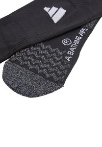 Schwarze Socken aus strukturiertem Stoff mit einem eleganten Design, einem grauen gemusterten Sohlen und weißen Logoakzenten.