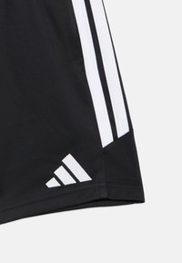 Μαύρα αθλητικά σορτς με λευκές πλαϊνές ρίγες και μια μικρή λευκή τριγωνική λεπτομέρεια κοντά στο στρίφωμα. Κατασκευασμένα από ελαφρύ ύφασμα.