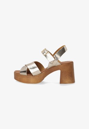 Metallic guld hælede sandaler med platform, der har to brede stropper og en ankelrem med spænde, sat på en tekstureret trælignende bund.