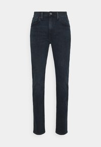 Mörkblå högmidjade slim-fit jeans med framknapp, dragkedja och femfickdesign, visade på en enkel vit bakgrund.