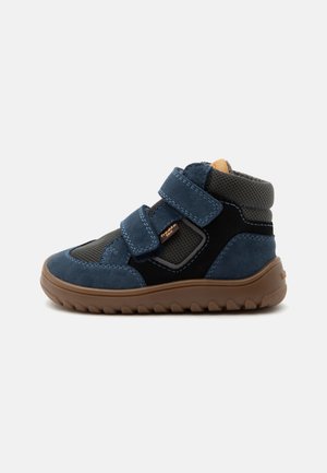 Baskets montantes pour tout-petit en bleu marine et noir avec deux bandes Velcro et une semelle en caoutchouc marron.