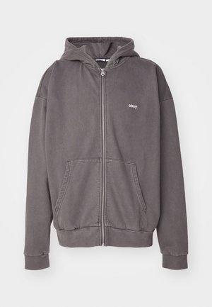 Šedá mikina na zip s bílým logem "obey", klokaní kapsy, elastické manžety a lem. Vyrobená z měkkého materiálu s neformálním designem.