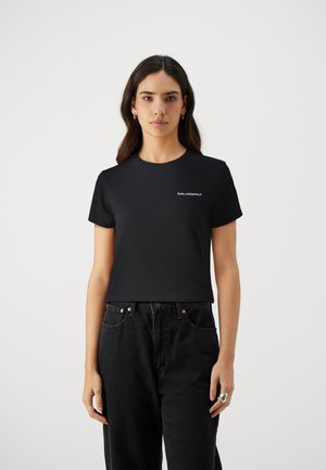 Tricou negru cu mânecă scurtă, cu guler rotund și branding minim în alb în zona stângă a pieptului. Țesătura pare netedă și ajustată.