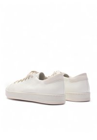 Białe skórzane trampki o fakturowanym wykończeniu, beżowe akcenty, okrągły nosek i sznurowadła w tonacji. Charakteryzują się minimalistycznym designem i gumową podeszwą.