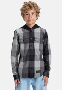 Černá a šedá kockovaná flanelová košile s černou kapucí, která má dvě přední kapsy, zapínání na knoflíky a texturovanou tkaninu.