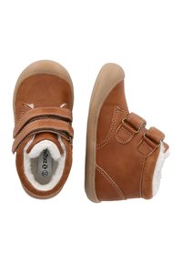 Bottes en suede marron avec double bande Velcro, doublure en peluche, semelle en caoutchouc, bout arrondi et détails de couture.