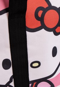 Borsa di Hello Kitty con un design rosa e bianco, una tracolla nera, tessuto texturizzato e dettagli distintivi del volto del personaggio.