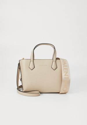 Bež torba od kože sa strukturiranim oblikom, dvostrukim ručkama na vrhu i odvojivim remenom. Ima zlatni logo i kontrastne crne rubove.