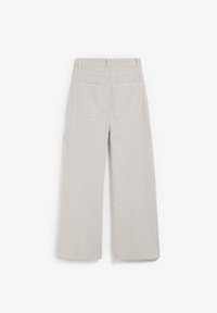 Pantalons en velours côtelé beige clair à jambes larges avec des côtes verticales, deux poches arrière et une ceinture unie.