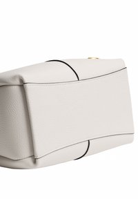 Sac à main en cuir blanc texturé avec finition noire incurvée et petit détail bouton doré sur un fond blanc uni.