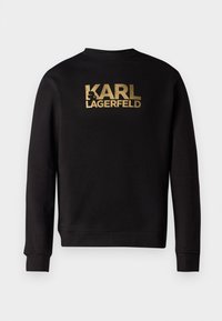 Čierna mikina s dlhým rukávom so zlatým nápisom "KARL LAGERFELD" a siluetou loga umiestnenou na strede hrude.