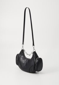 Black leather handbag with a curved design, featuring two side zippered pockets, a chain-accented strap, and smooth texture.