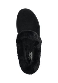 Zwarte suède instappers met een zachte faux fur voering rond de opening, een ronde neus en een platte zool. Label zichtbaar aan de binnenkant.