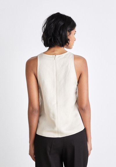 Beige sleeveless top made of lightweight fabric, featuring a round neckline and a back zipper detail. Smooth texture, minimal design.