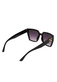 Czarne okulary przeciwsłoneczne o geometrycznym wzorze, z błyszczącym wykończeniem, ciemnymi gradientowymi soczewkami oraz złotymi akcentami na zausznikach.