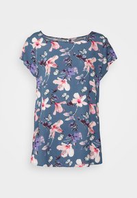 Camisa de manga curta floral em tecido azul, com flores e borboletas rosas e roxas, com um corte solto e decote redondo.