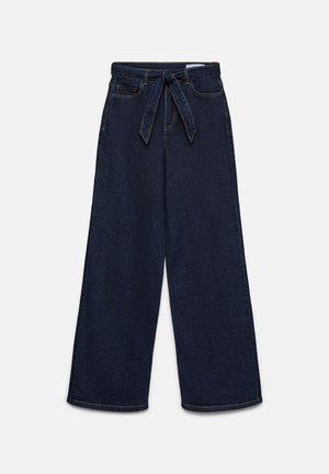 Høytlivs mørkeblå vidbukser med frontlommer og matchende stoffbelte knyttet i midjen.