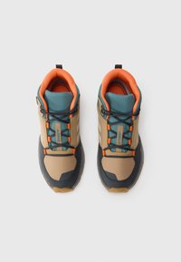 Beige and navy hiking shoes with a textured design, orange and teal accents, and a secure lacing system, viewed from above.