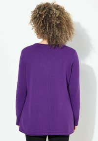 Maglione viola a maniche lunghe con scollatura rotonda, texture a costine e vestibilità comoda. Il tessuto appare liscio con dettagli di cucitura sottili.