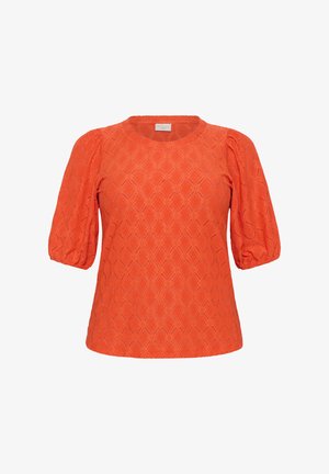 Top scurt, de culoare portocalie strălucitoare, cu un model texturat în formă de diamant și mâneci bombate. Guler rotund și o croială ușor lejeră.
