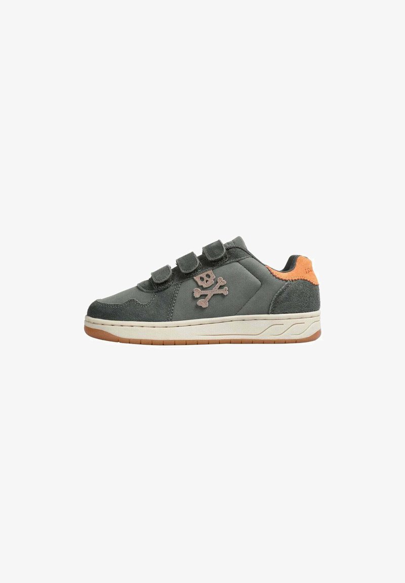 Zapatilla gris oscuro con tres correas de velcro negras, suela beige, detalle del talón naranja y un logo de calavera y huesos cruzados en el lateral.