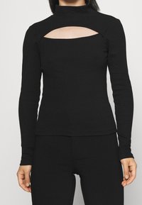 Long-sleeve black top with a mock neck and a large cut-out design at the chest. Made from stretchy fabric, it features a fitted silhouette.