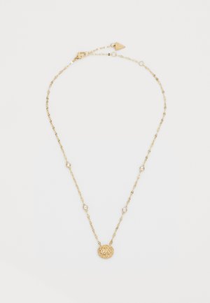 Złoty naszyjnik z łańcuchem, zdobiony zawieszką w kształcie muszli z bruzdami, akcentowany małymi, okrągłymi, przezroczystymi kamieniami, umieszczonymi wzdłuż łańcucha.