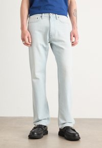 Blugi de culoare albastru deschis, cu un croi drept, fabricați din denim. Prezintă un etichetă Calvin Klein, închidere cu button și fermoar, și un design cu cinci buzunare.