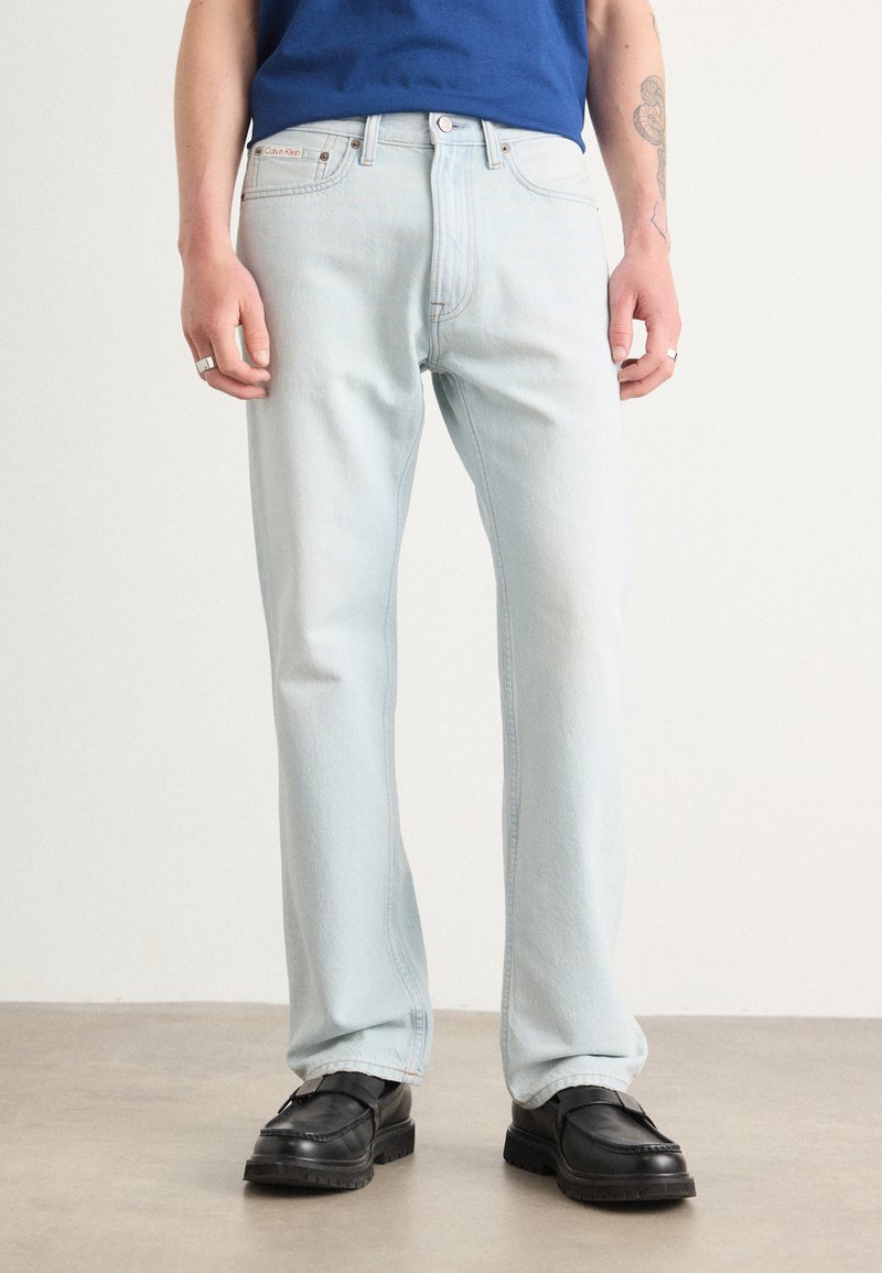 Blugi de culoare albastru deschis, cu un croi drept, fabricați din denim. Prezintă un etichetă Calvin Klein, închidere cu button și fermoar, și un design cu cinci buzunare.