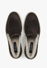 Brązowe zamszowe buty typu slip-on z miękkim, kremowym sztucznym futerkiem w środku. Zawierają okrągły czubek oraz jasną gumową podeszwę.