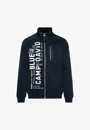 Marine sweatshirt met hoge kraag, ritssluiting en zak op de linker borst. Bevat witte en blauwe bedrukte tekst en logo details aan de voorkant.