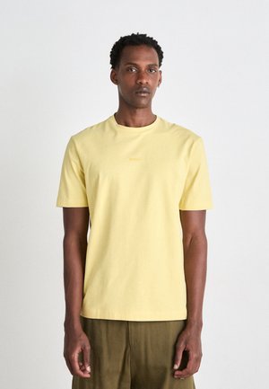 T-shirt met korte mouwen en ronde hals in zachtgele katoen, voorzien van een subtiel reliëflogo in lichtoranje op de borst.