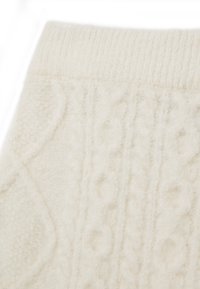 Pull en laine crème avec un motif en relief en câble, ourlet côtelé et matériau doux et duveteux pour plus de chaleur et de confort.