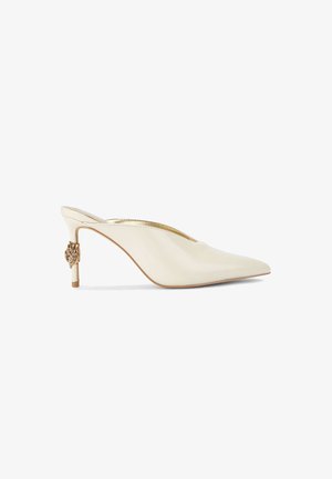 Mulo a punta in pelle lucida crema con tacco accentato in oro, caratterizzato da un elemento decorativo sul retro e una silhouette elegante.
