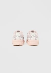 Pantofi sport albi și roz pal cu partea superioară din plasă, detalii texturate, accente pastelate moi și talpă cu amortizare, văzuți din spate.