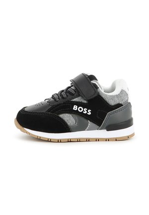 Baskets pour enfants noires, grises et blanches avec des lacets, une bride Velcro et le mot "BOSS" sur le côté, vues de l'extérieur.