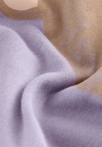 Tessuto lavorato a maglia nei colori lilla e marrone chiaro, che mostra una fine texture con una caduta morbida. Presenta una miscela di materiali per una sensazione accogliente.