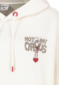 Cremfarbene Baumwollkapuzenjacke mit einem Grafikdesign eines Affen und dem Text "NICHT MEIN ZIRKUS". Rote Kordel und herzförmiges Detail unterhalb der Grafik.
