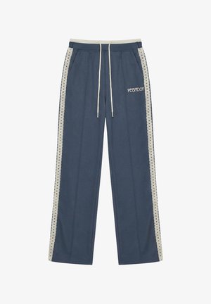 Modré široké tepláky s bílými krajkovými pruhy po stranách, stahovací šňůrkou v pase a logem "PEGADOR" na levé horní noze.